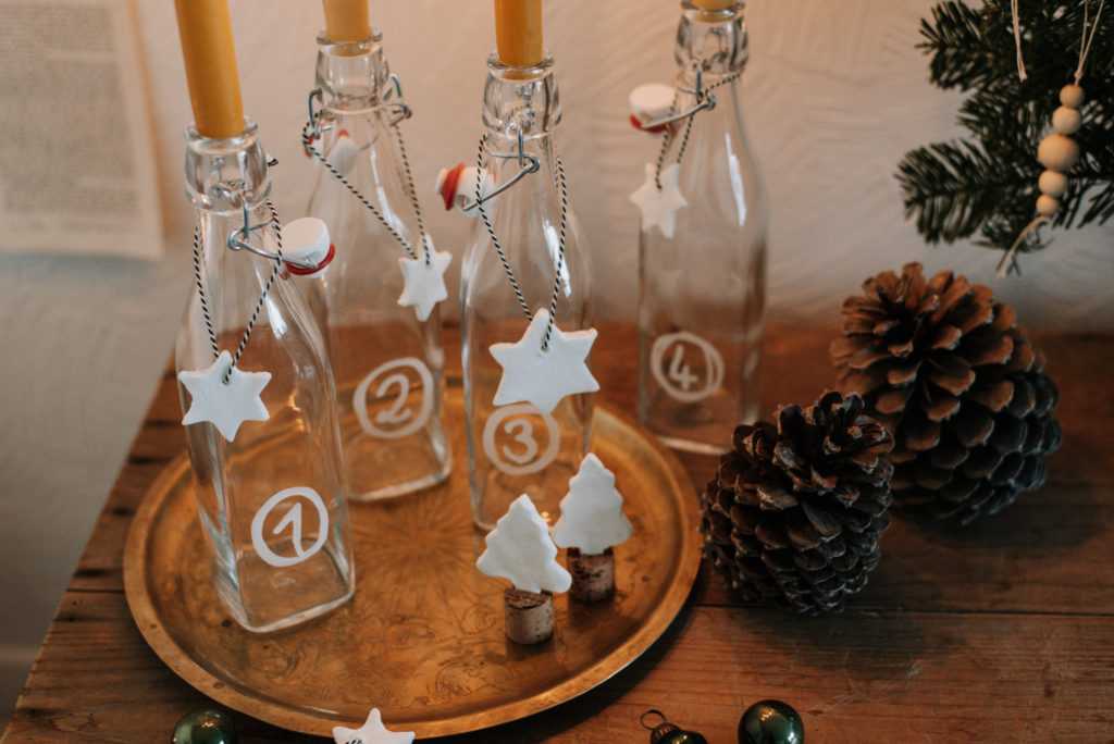 Einfaches Upcycling DIY: Last Minute Adventskranz aus leeren Flaschen einfach selber machen und warmleuchtende Kerzen brennen lassen