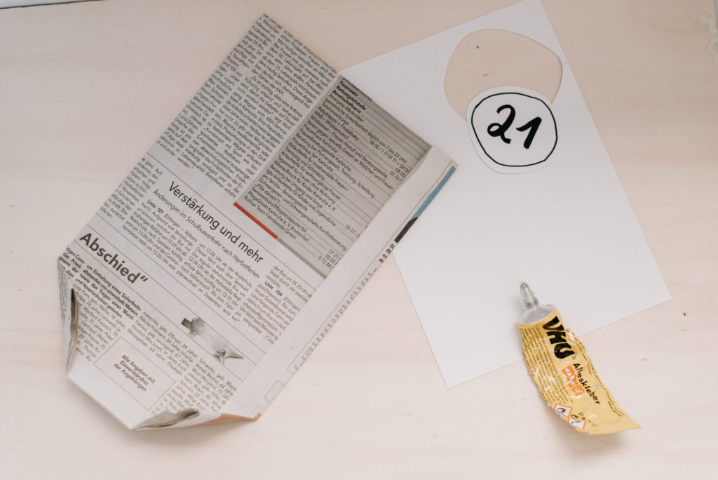 Upcycling DIY Adventskalender selber machen: Papiertüten aus alten Zeitungen basteln, Zahlen darauf schreiben und Geschenke darin verpacken