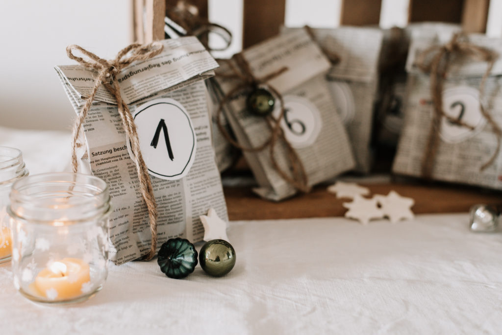 Upcycling DIY Adventskalender selber machen: Papiertüten aus alten Zeitungen basteln, Zahlen darauf schreiben und Geschenke darin verpacken