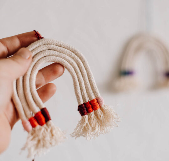 DIY Makramee Regenbogen: Regenbogen aus Wolle-Resten selber machen. Als Geschenkanhänger, Geschenk zur Geburt oder Deko für's Kinderzimmer.